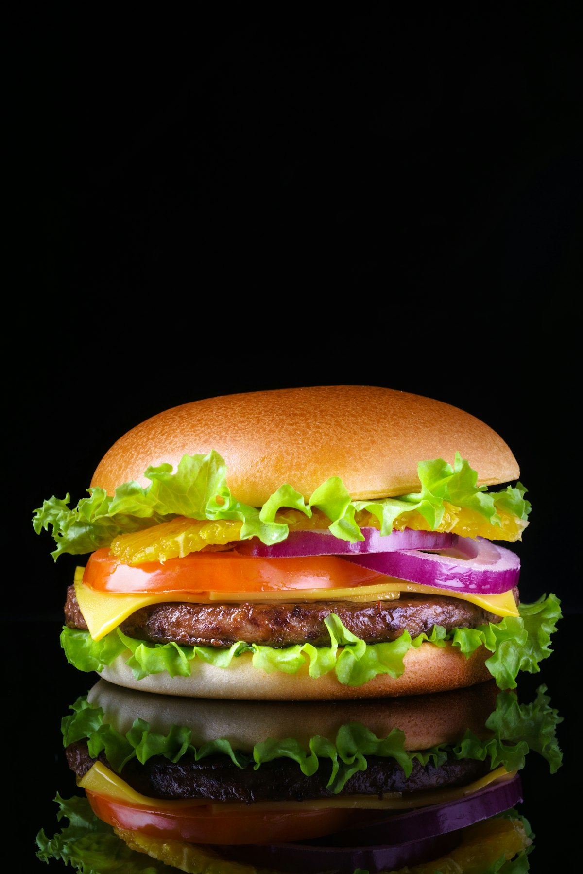 Saftiger Burger mit Salat, Tomaten und roten Zwiebeln